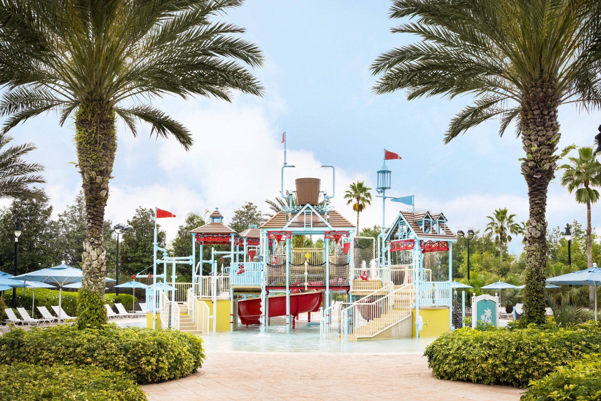 a water park with palm trees and a slide in the middle of it