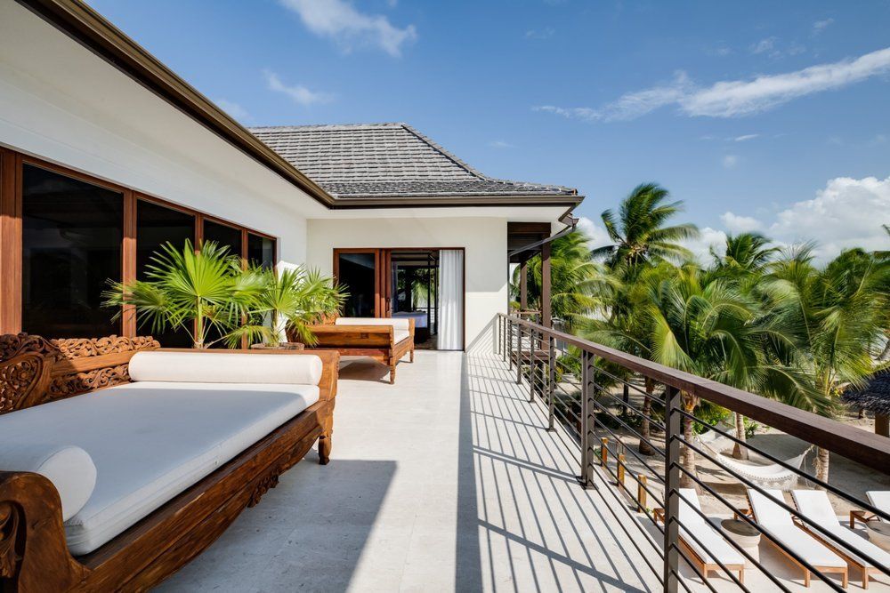 a large balcony with a couch and chairs on it