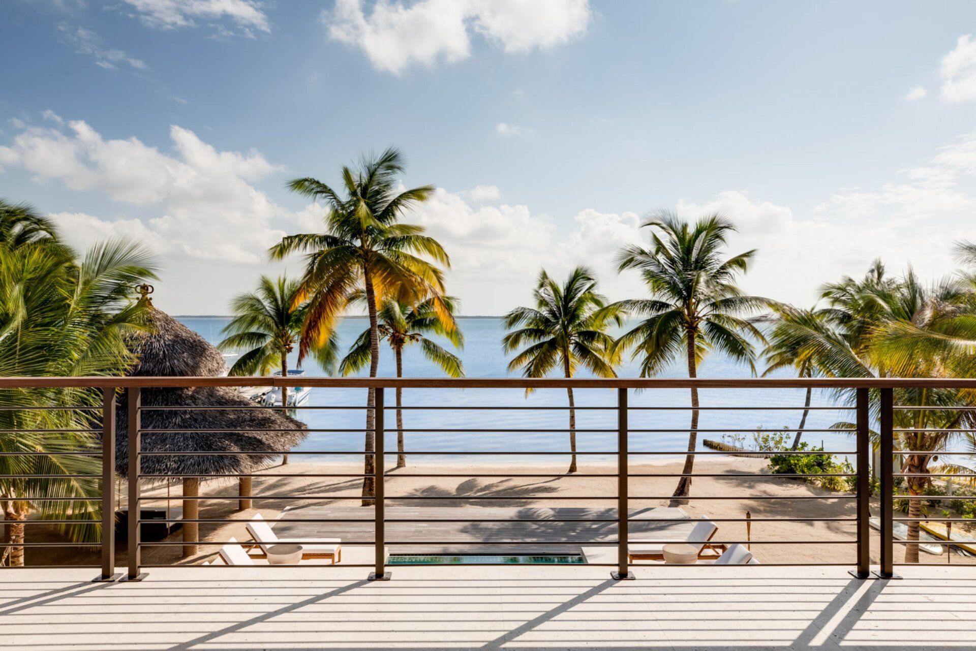 a balcony with a view of the ocean and palm trees