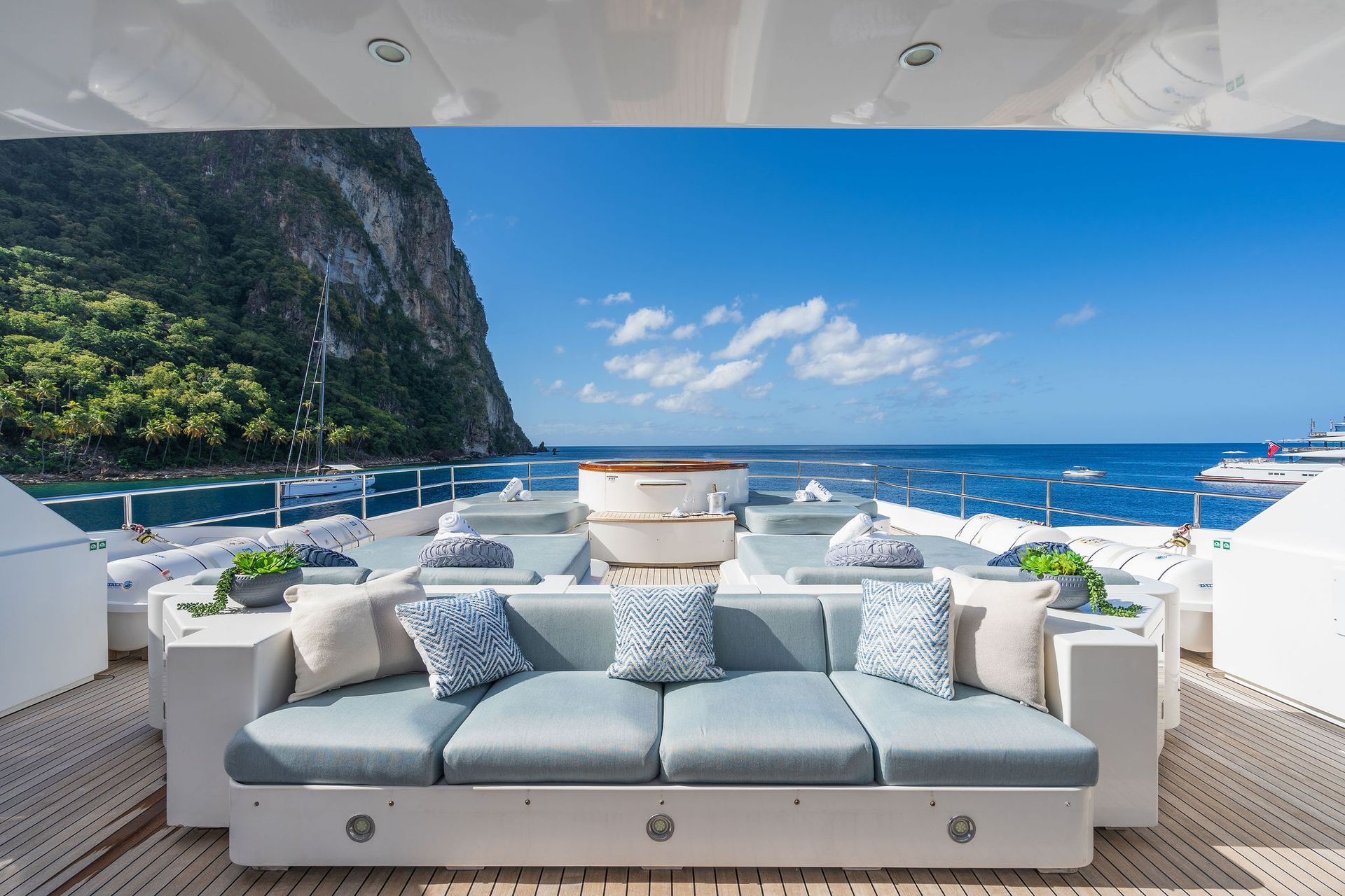 there is a couch on the deck of a yacht with a view of the ocean