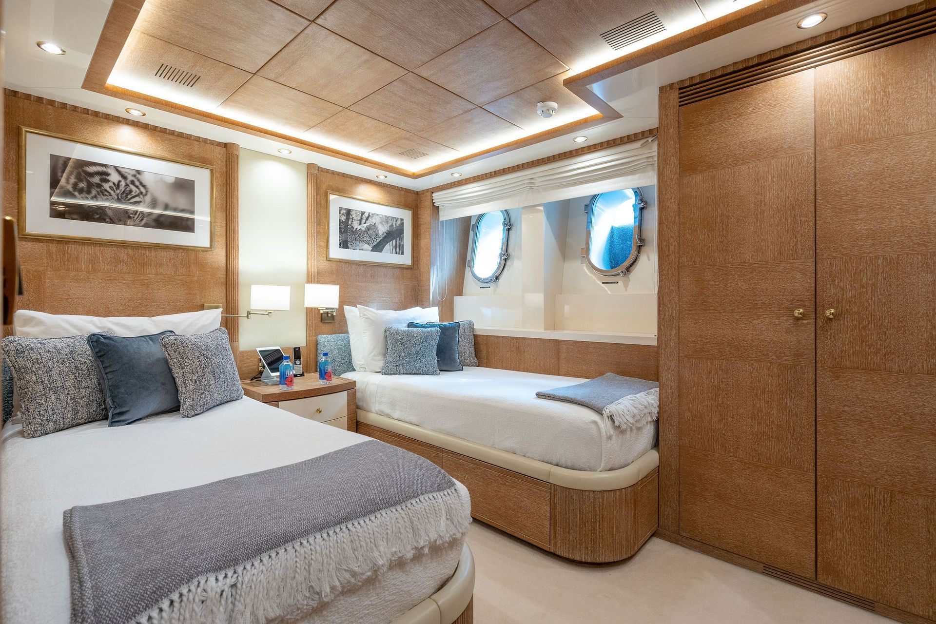 a bedroom on a yacht with two beds and a closet