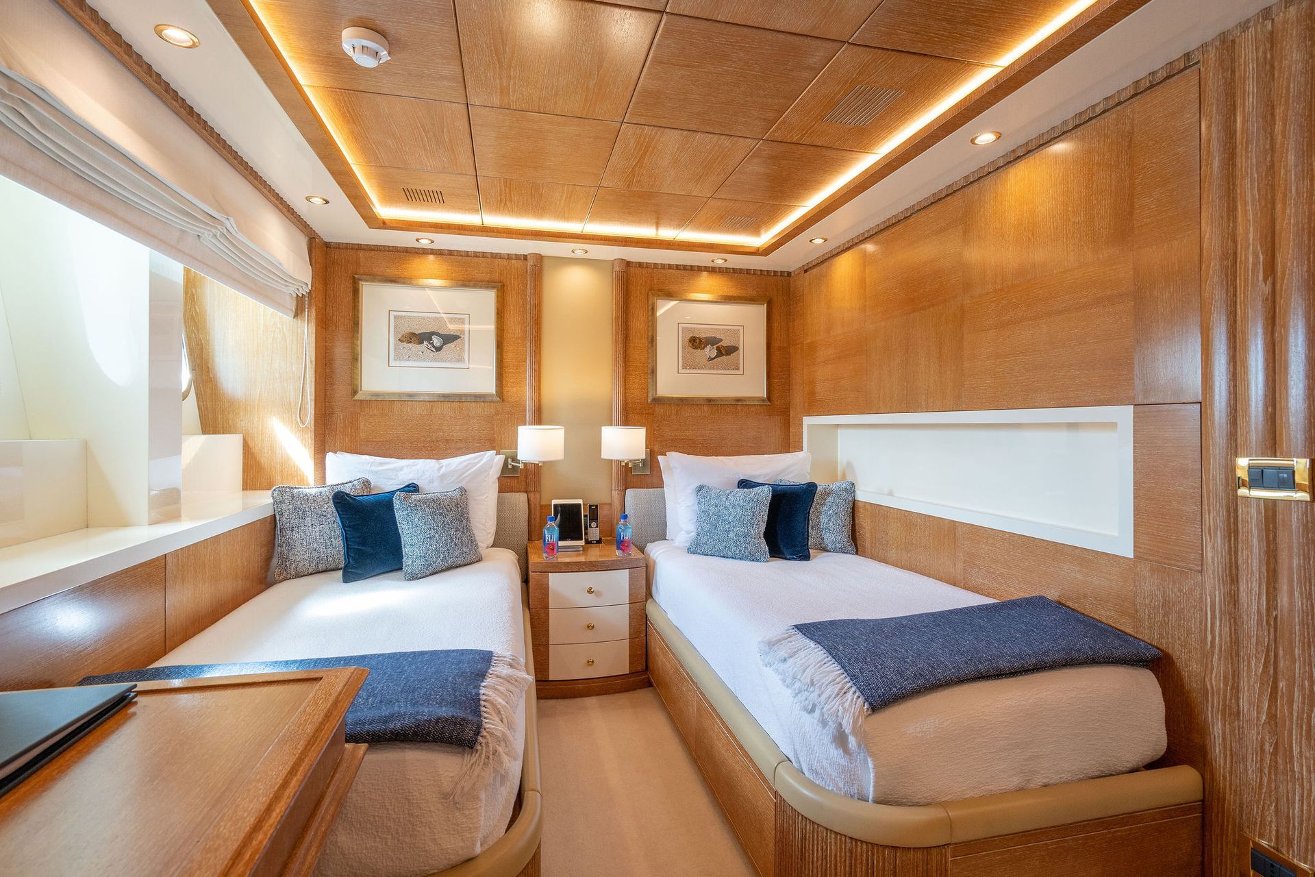 a bedroom on a yacht with two beds and a window