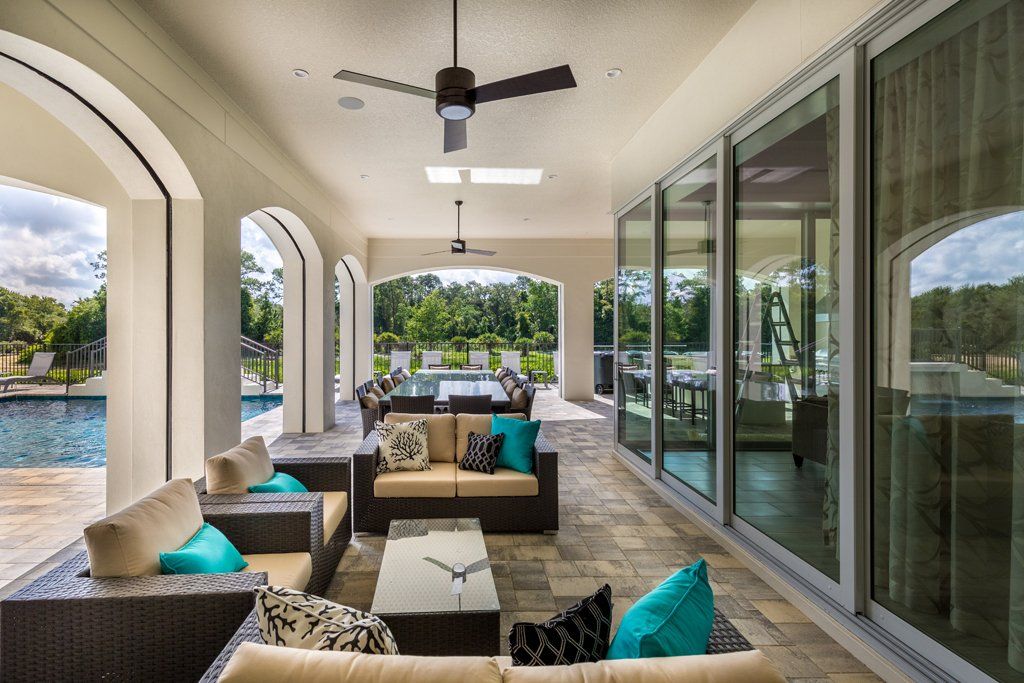 a patio with a lot of furniture and a ceiling fan