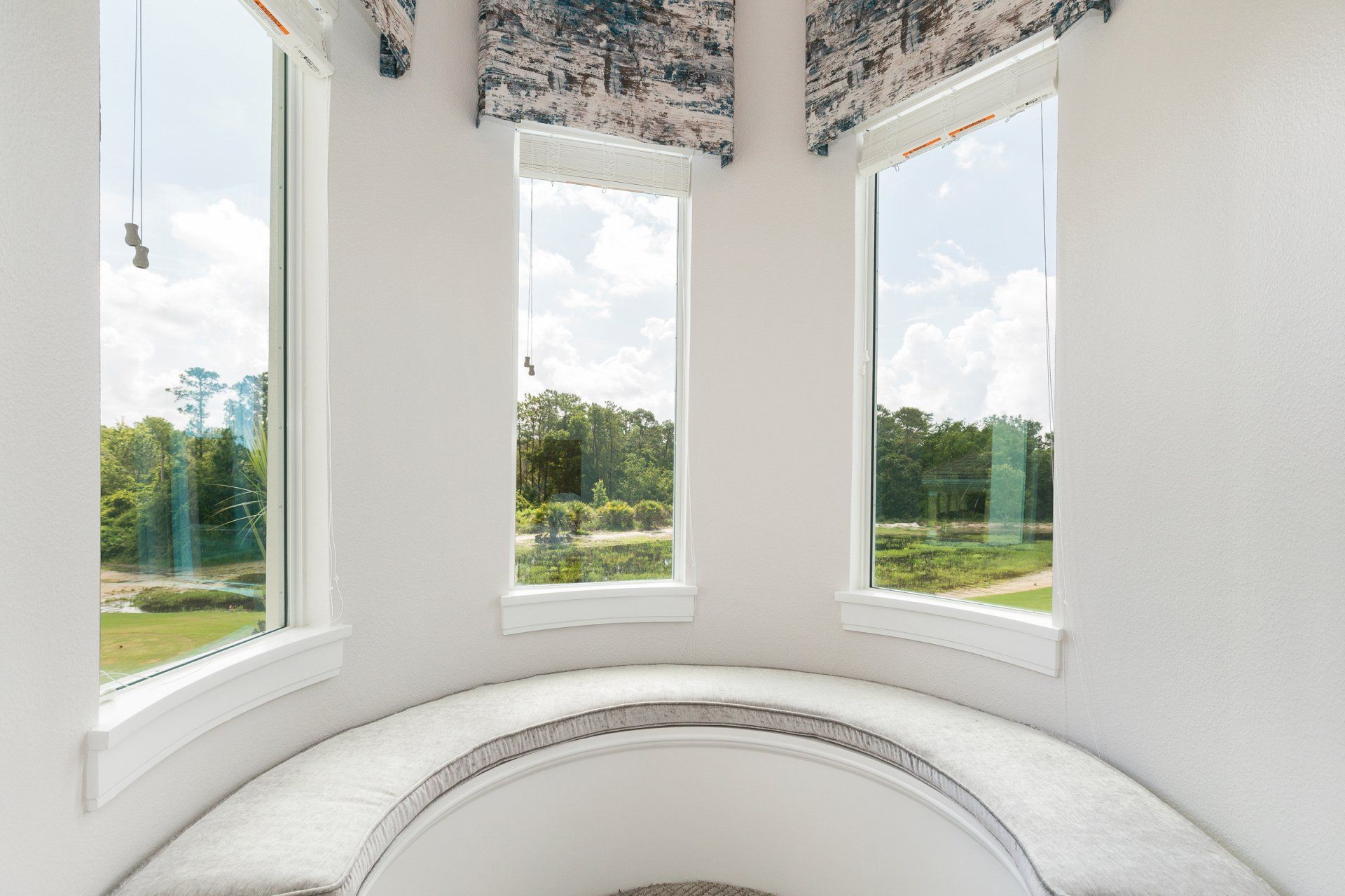 a round window seat in a room with a lot of windows