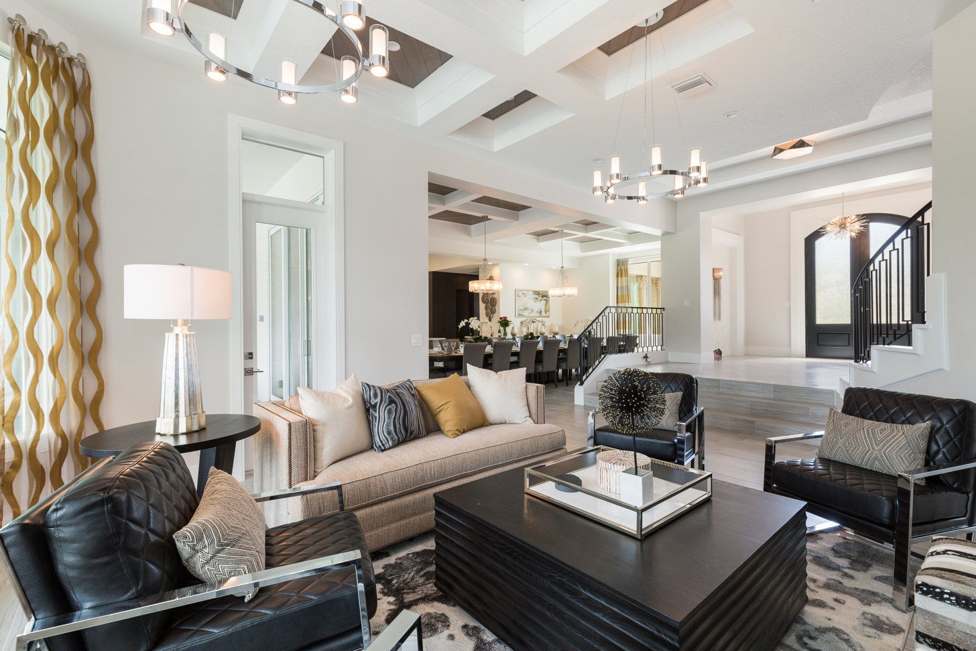 a living room with a couch, chairs, coffee table and chandelier