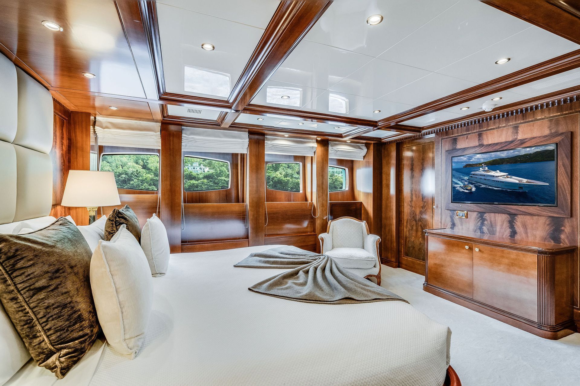 a bedroom on a yacht with a large bed and a flat screen tv