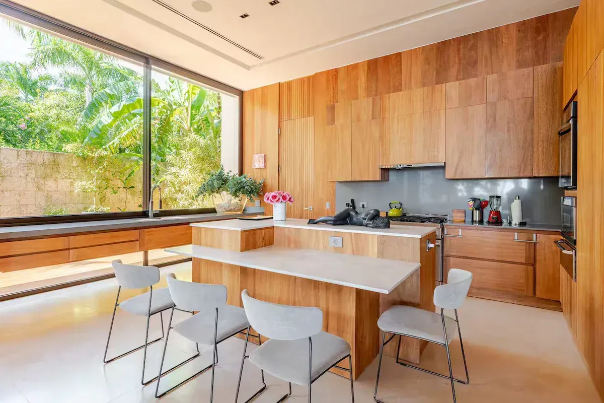 a kitchen with a large island and stools in a house