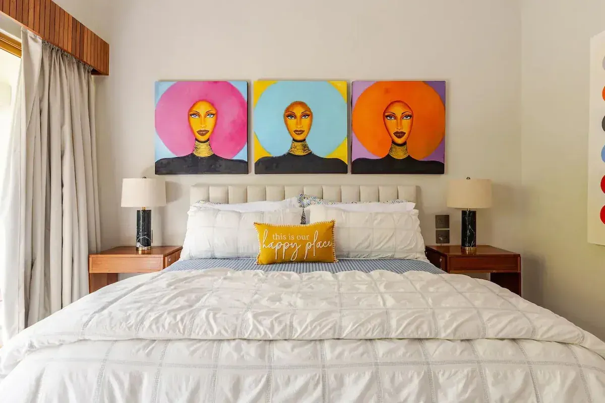 a bedroom with a large bed and a painting on the wall