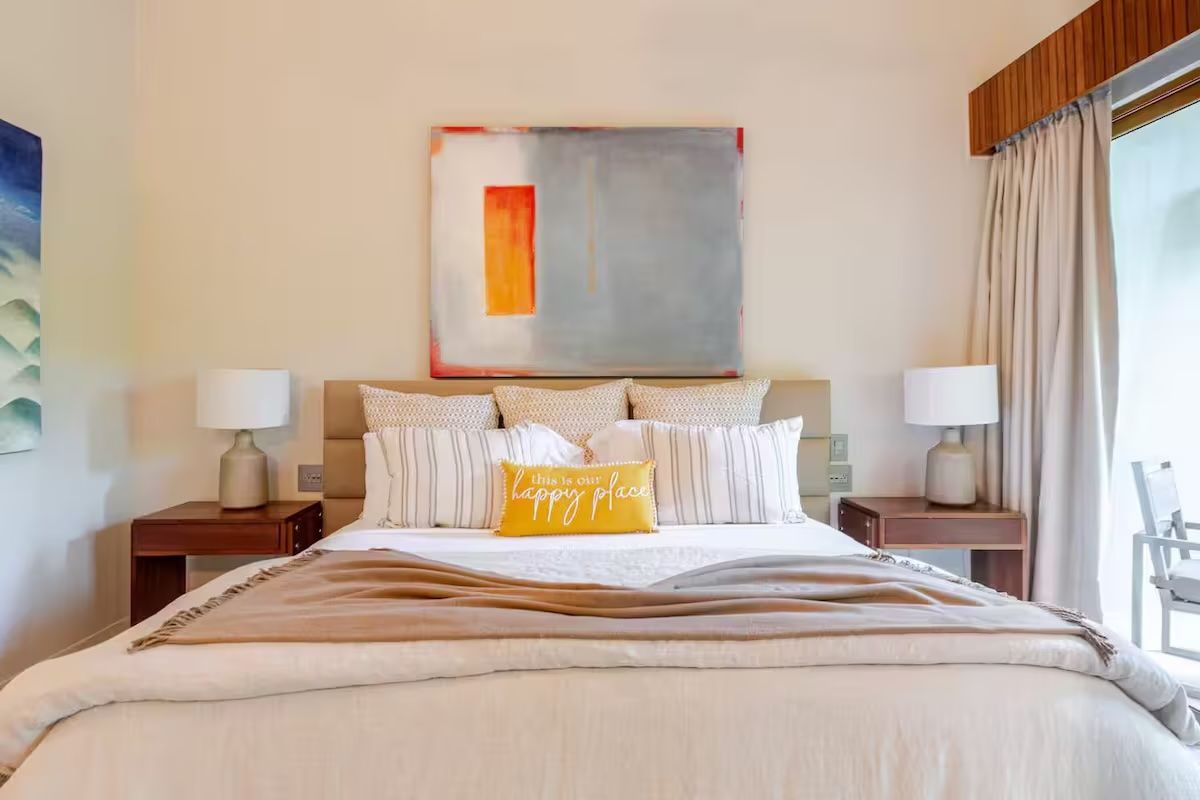 a bedroom with a bed, nightstand, lamps and a ceiling fan