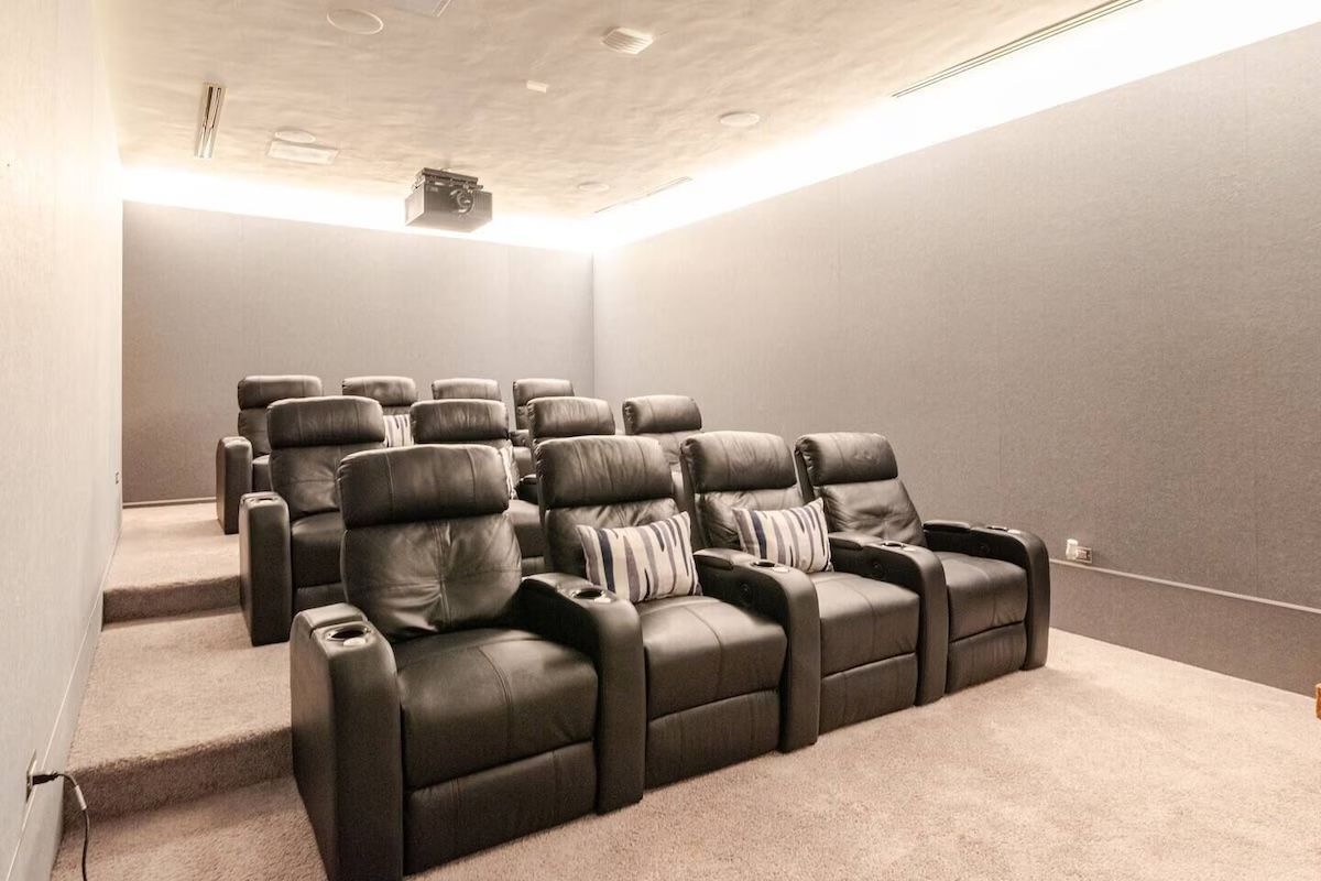 a family is sitting in a home theater watching a movie