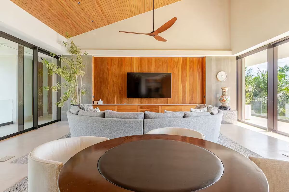 a man and woman are sitting on a couch in a living room with a mural on the wall