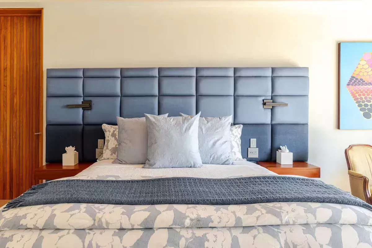 a bedroom with a large bed, a couch, a television and a ceiling fan