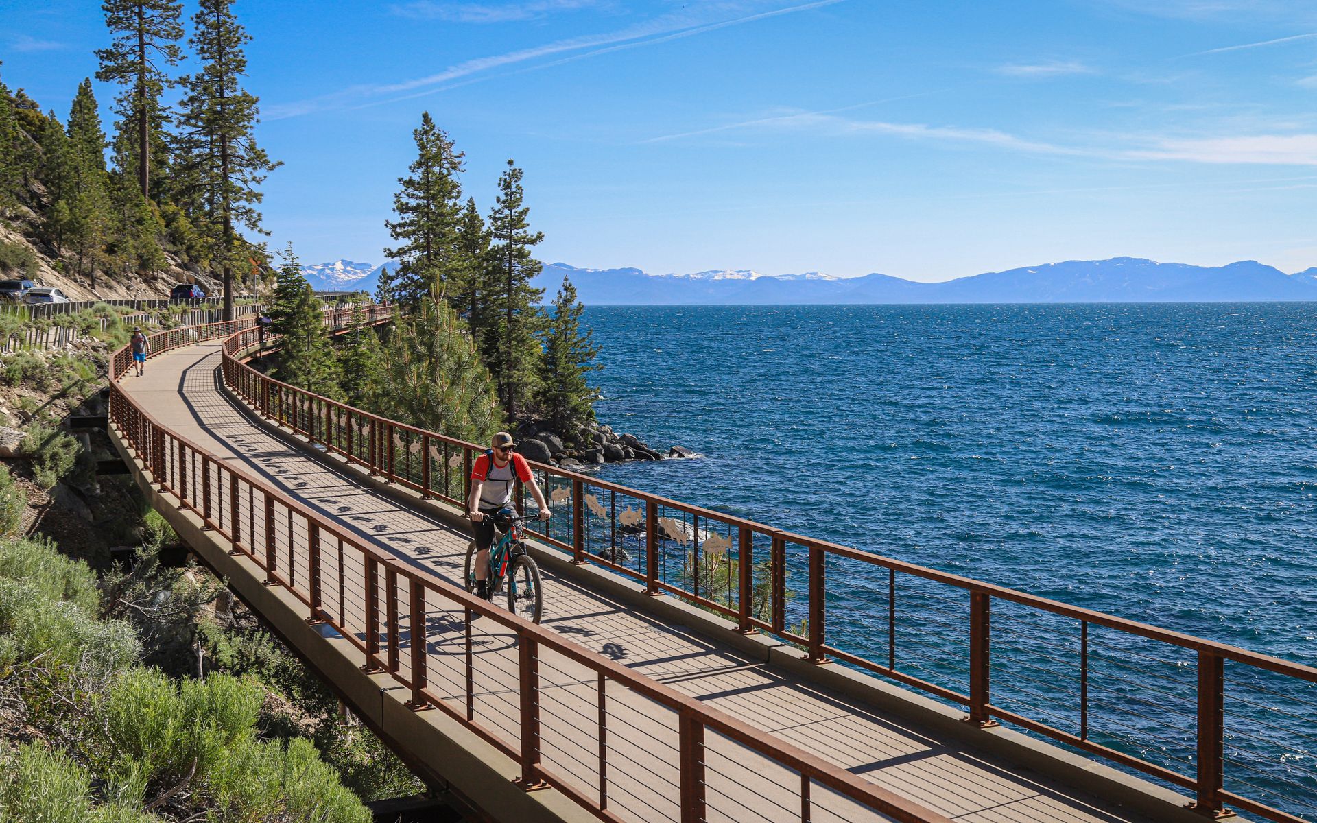 a person is riding a bike on a bridge over a lake