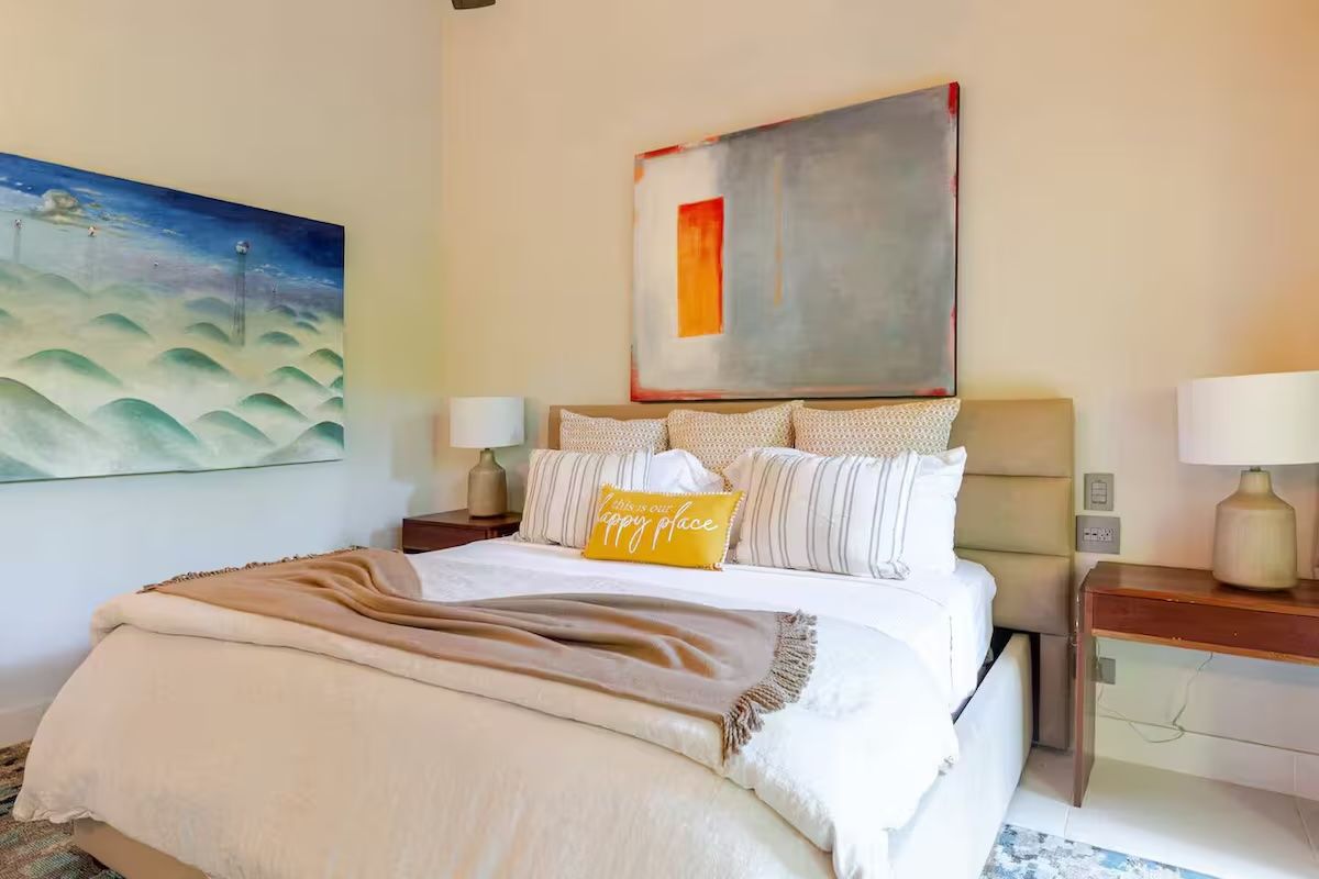 a bedroom with a large bed, dresser and chair