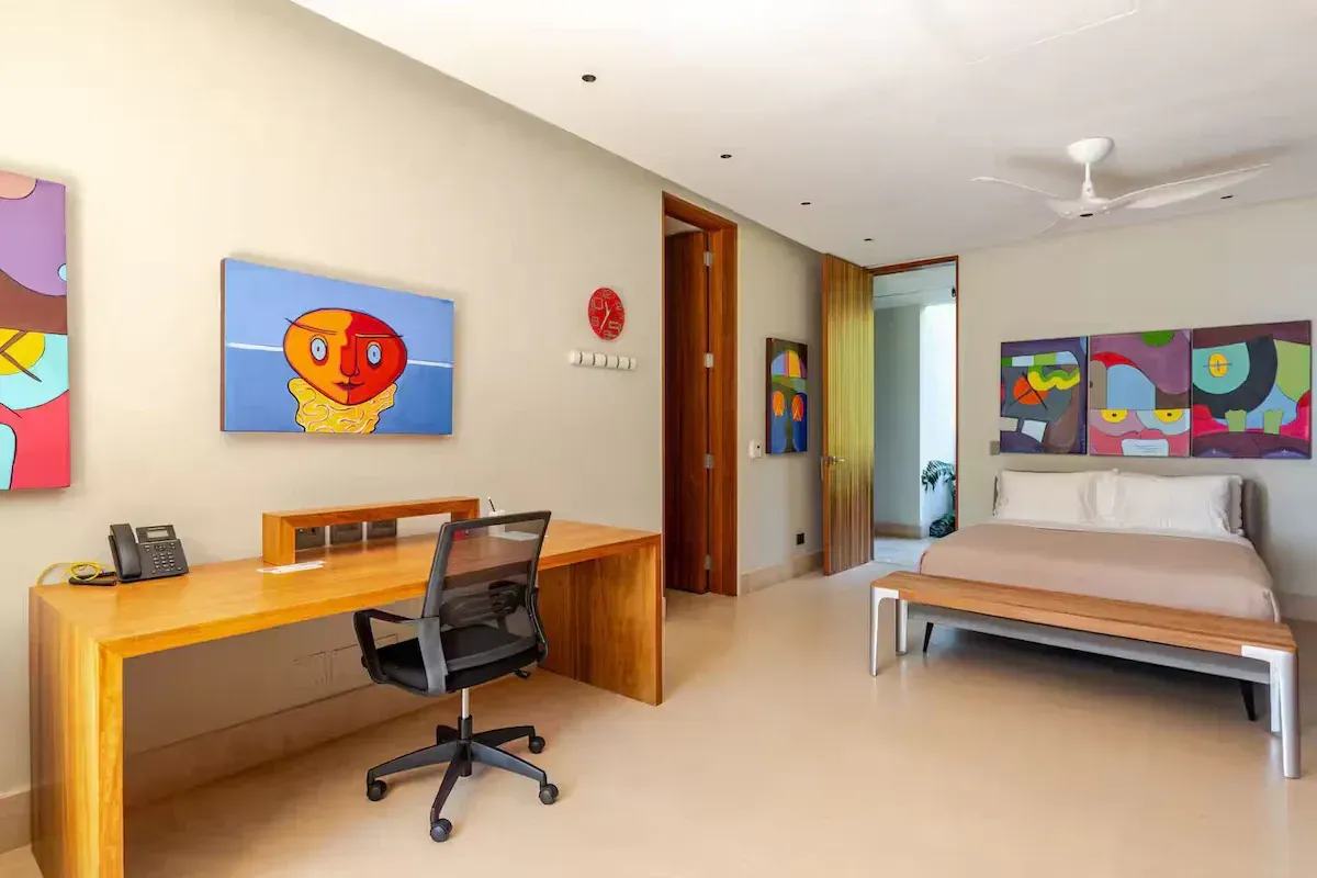a bedroom with a king size bed, a bench, a dresser and a ceiling fan