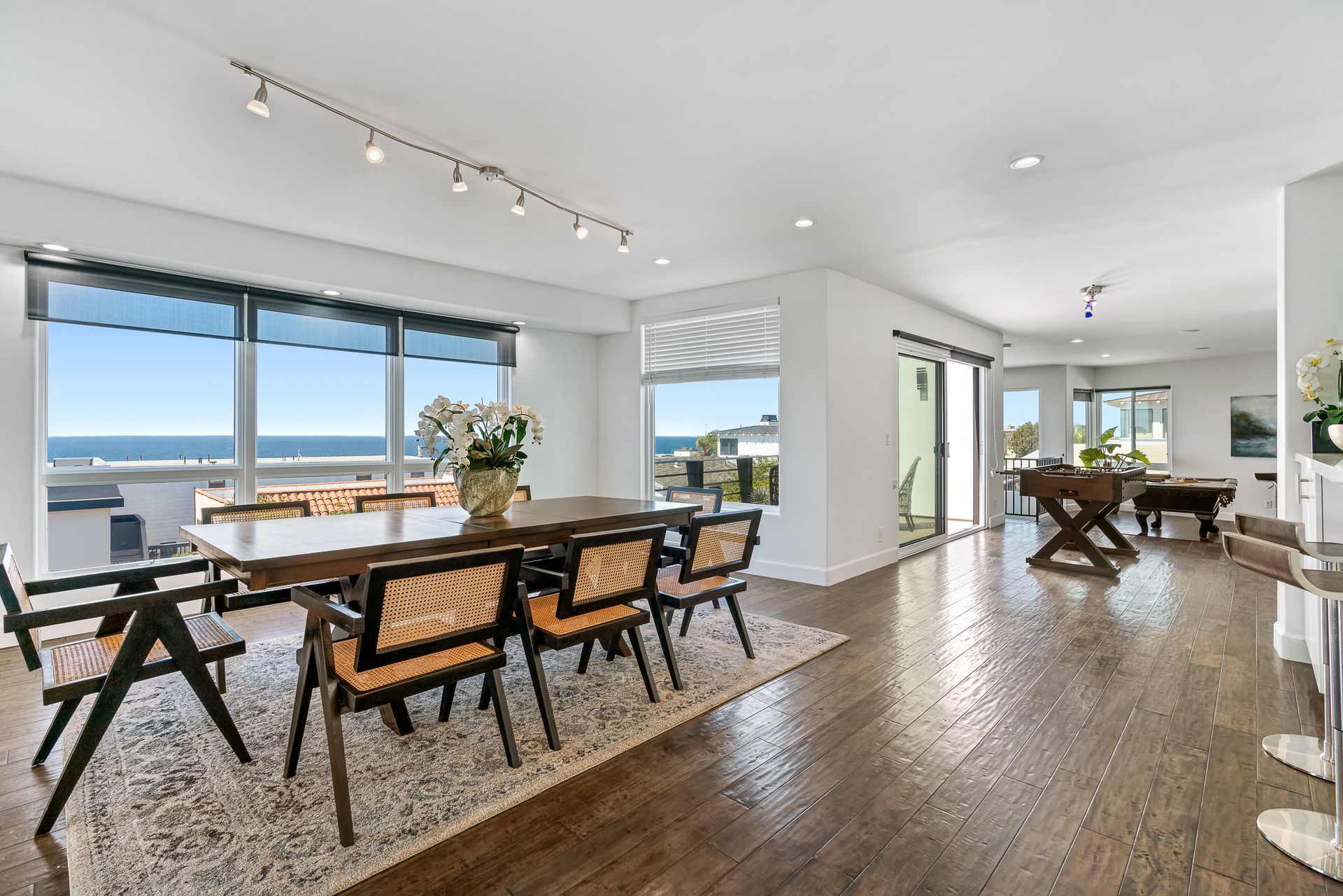 a dining room with a round table and chairs and a lot of windows