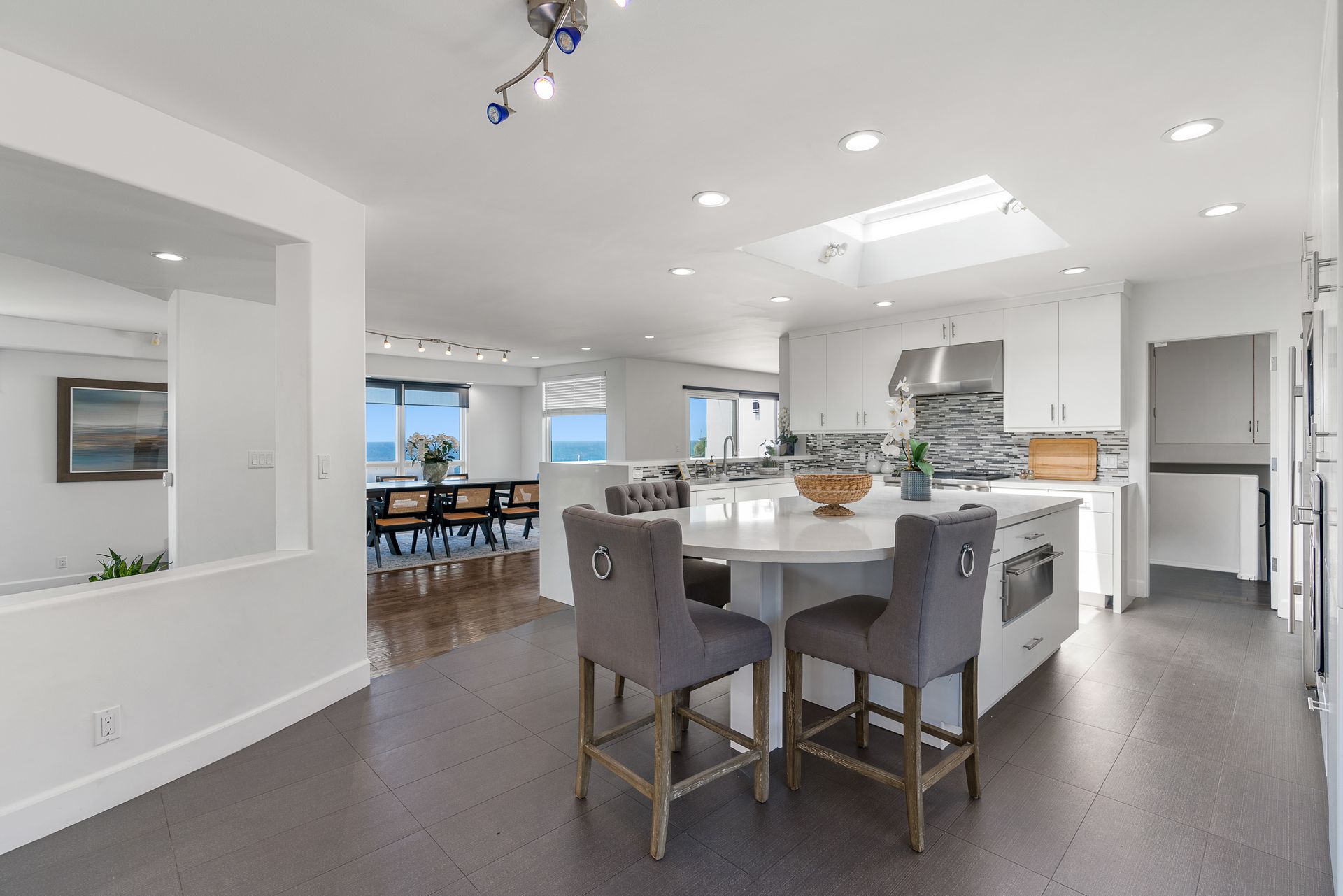 a kitchen with stainless steel appliances, wooden cabinets, a sink, and three windows