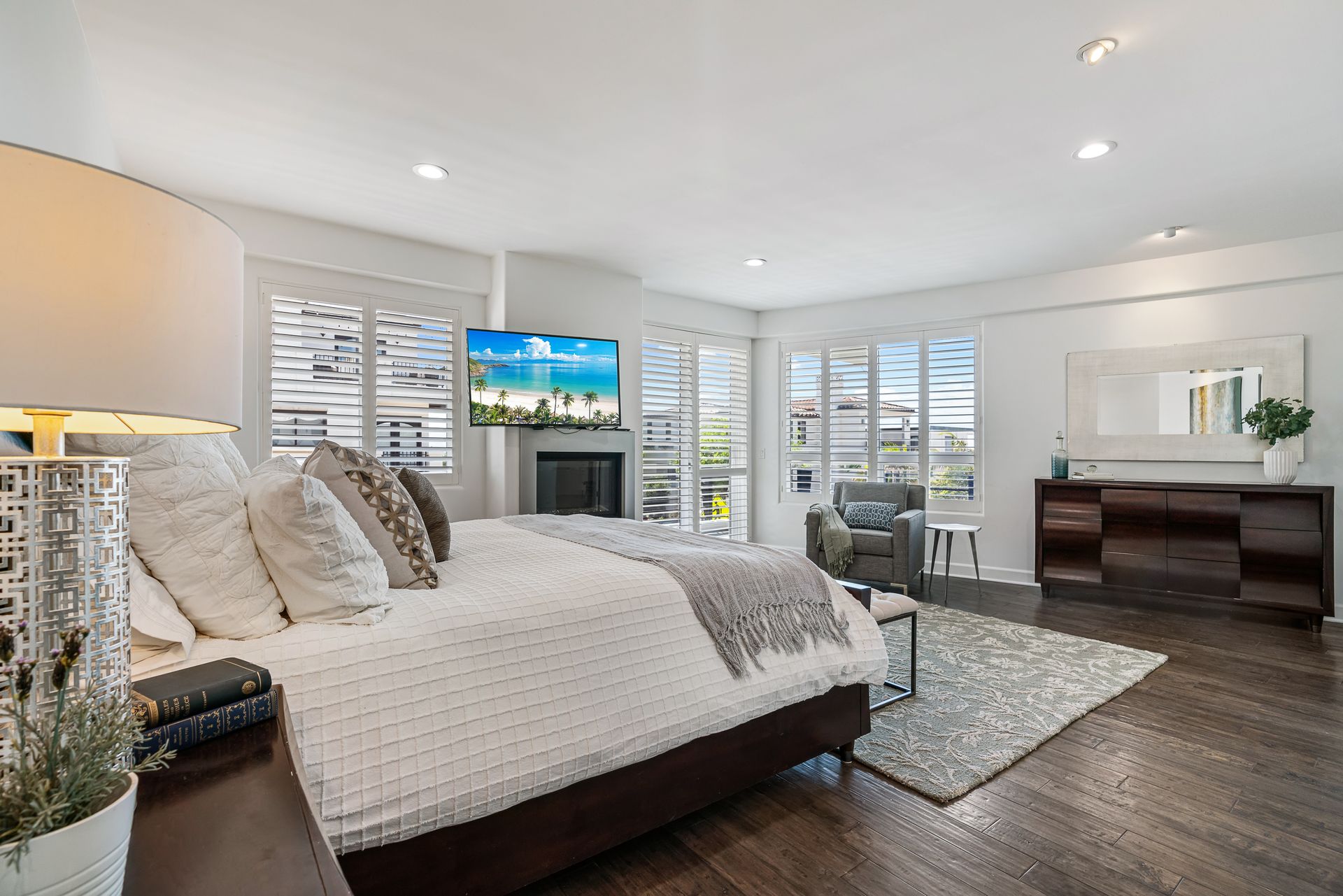 a bedroom with a large bed, dresser, nightstand and sliding glass doors