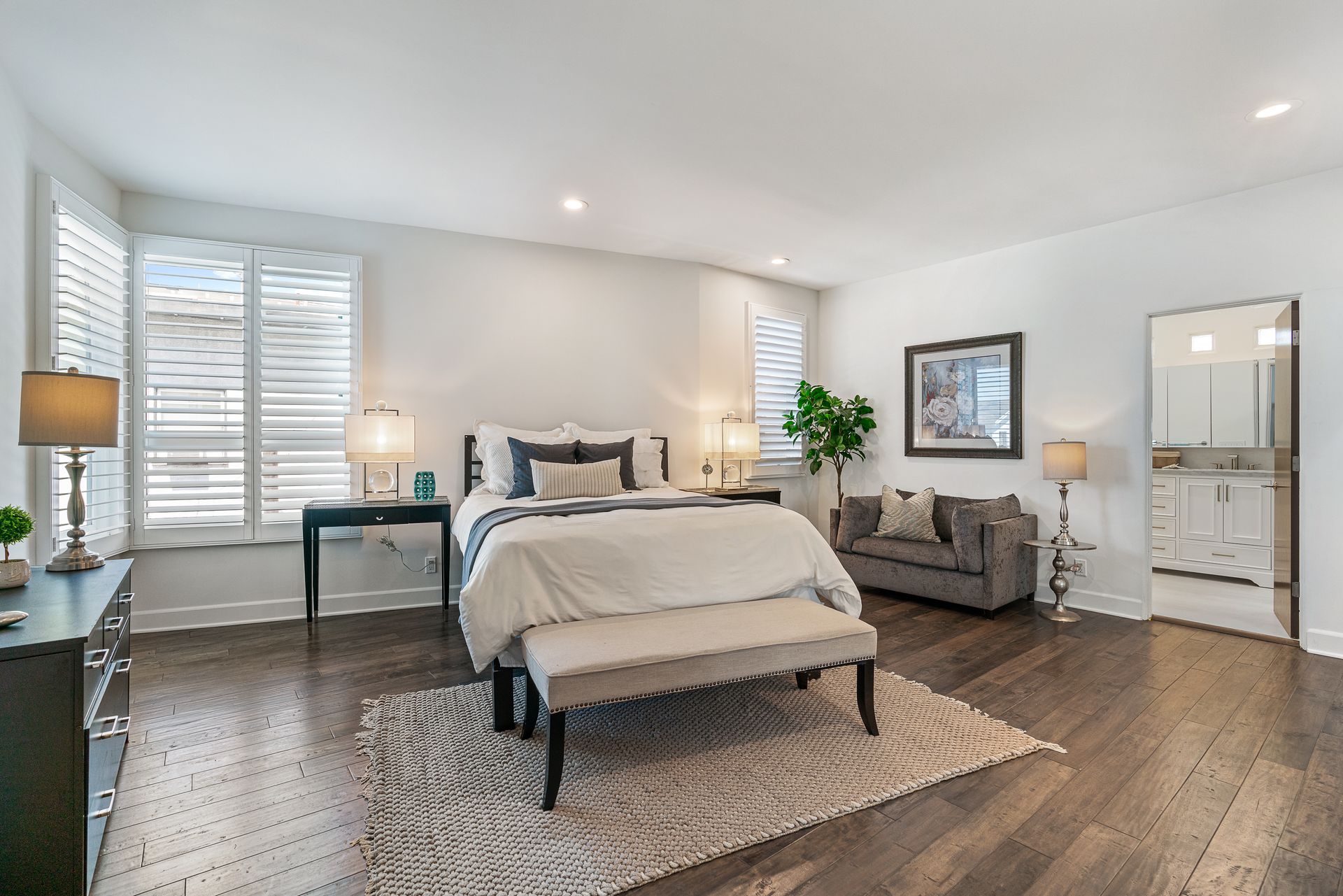 a bedroom with a large bed and lots of windows