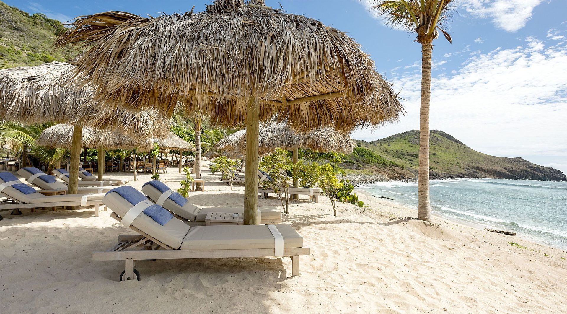 a beach with thatched umbrellas and chairs on it