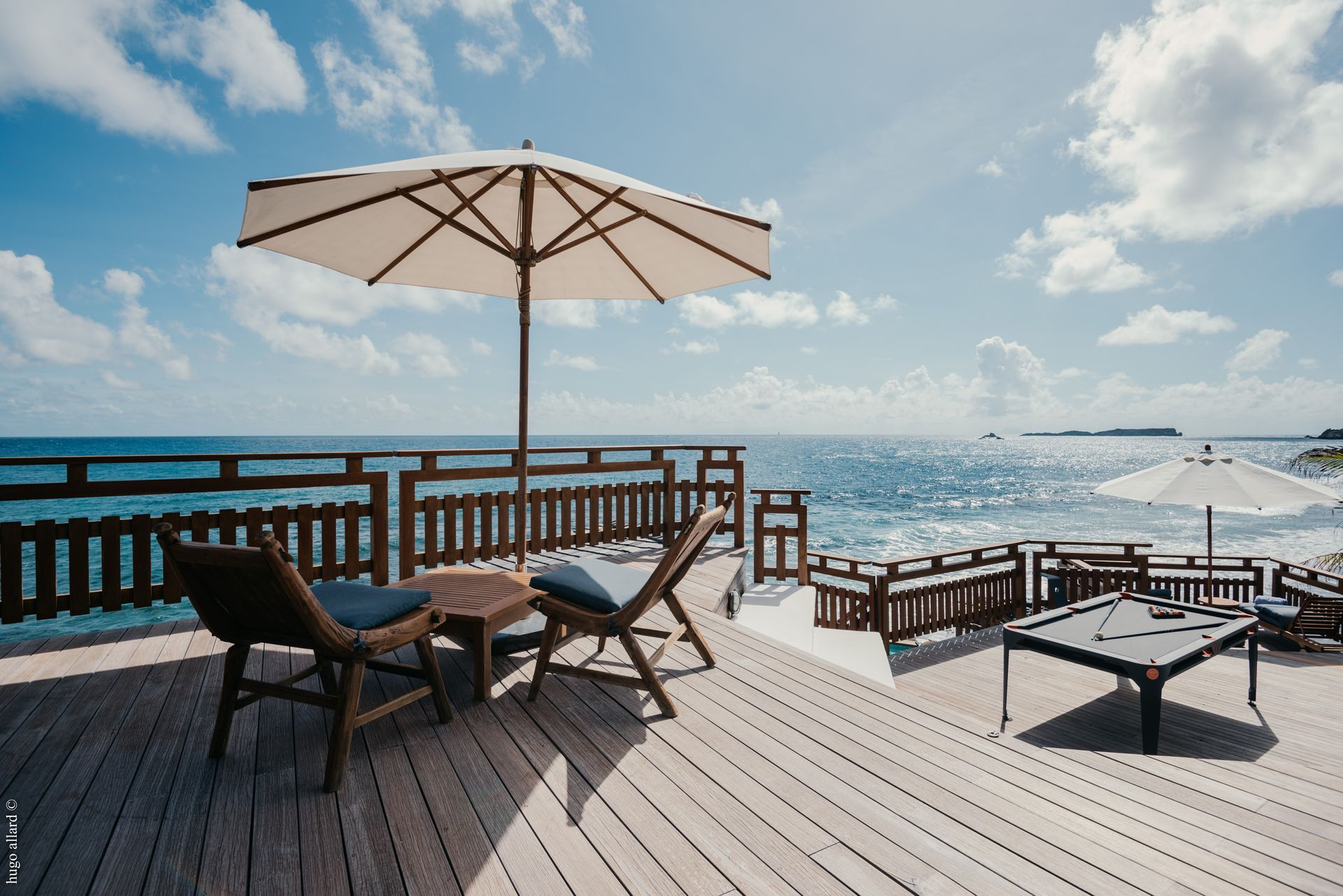 a deck with chairs and umbrellas overlooking the ocean