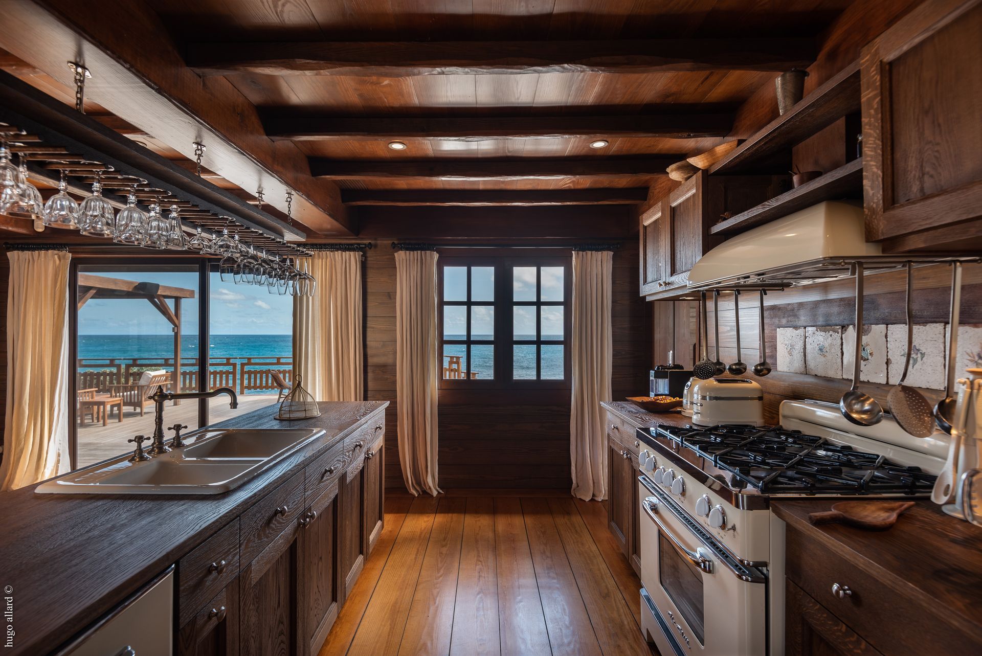a kitchen with a stove a sink and a view of the ocean