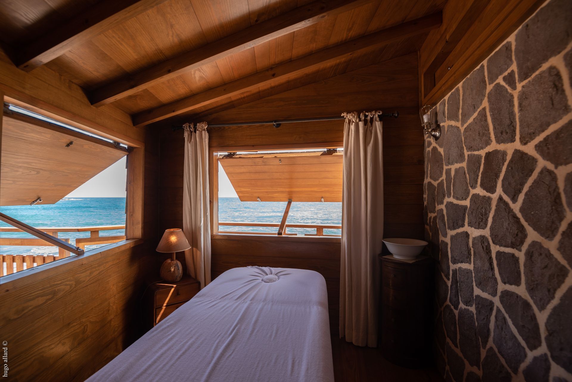 there is a massage table in the middle of the room with a view of the ocean