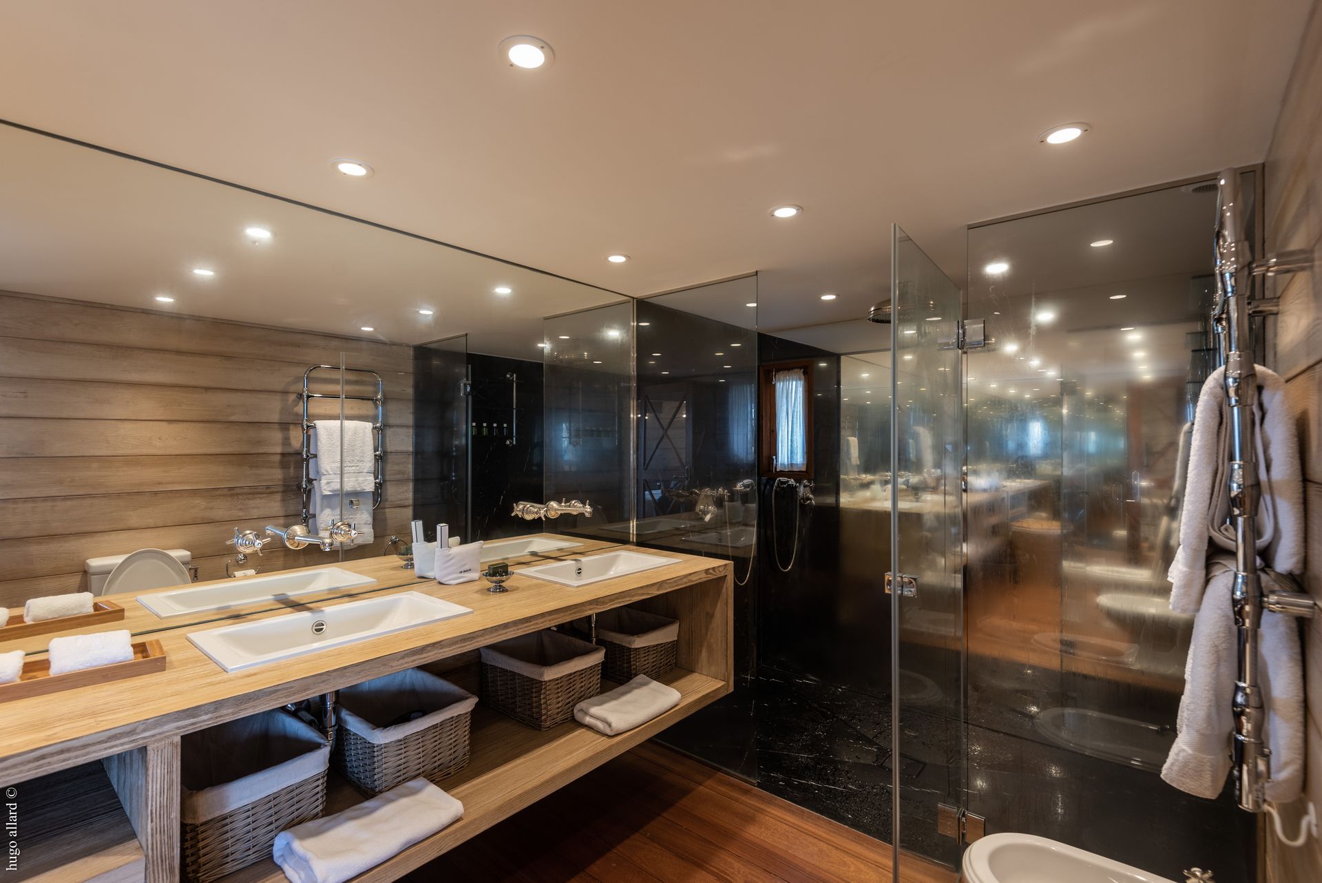 a bathroom with two sinks, a toilet and a walk in shower