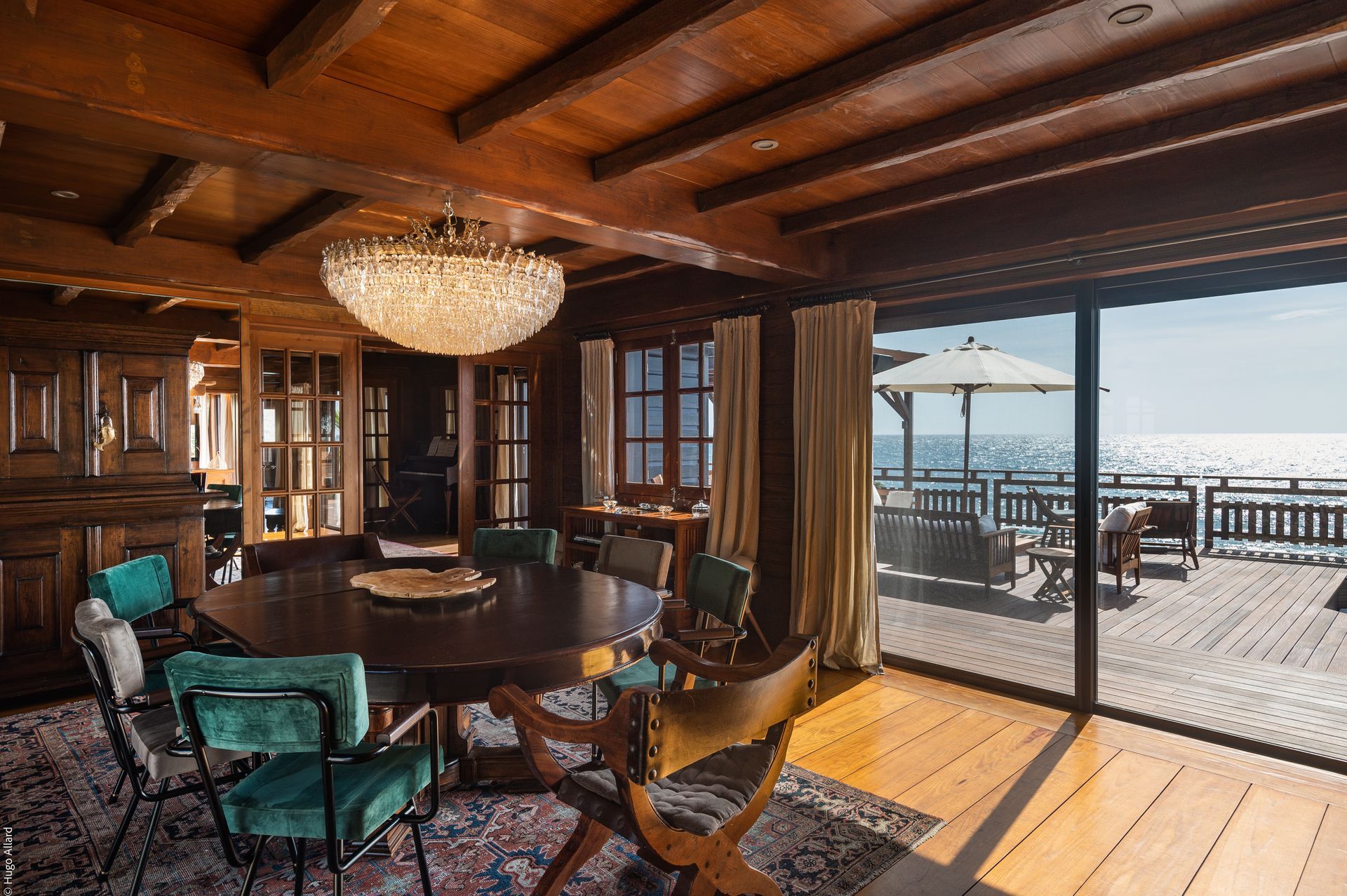 a dining room with a table and chairs and a view of the ocean