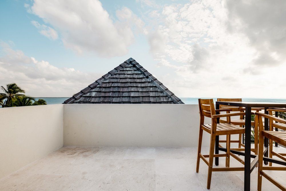 a balcony with a table and chairs overlooking the ocean