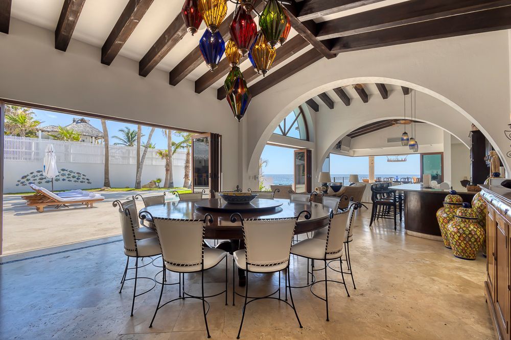 a dining room with a table and chairs and a view of the ocean