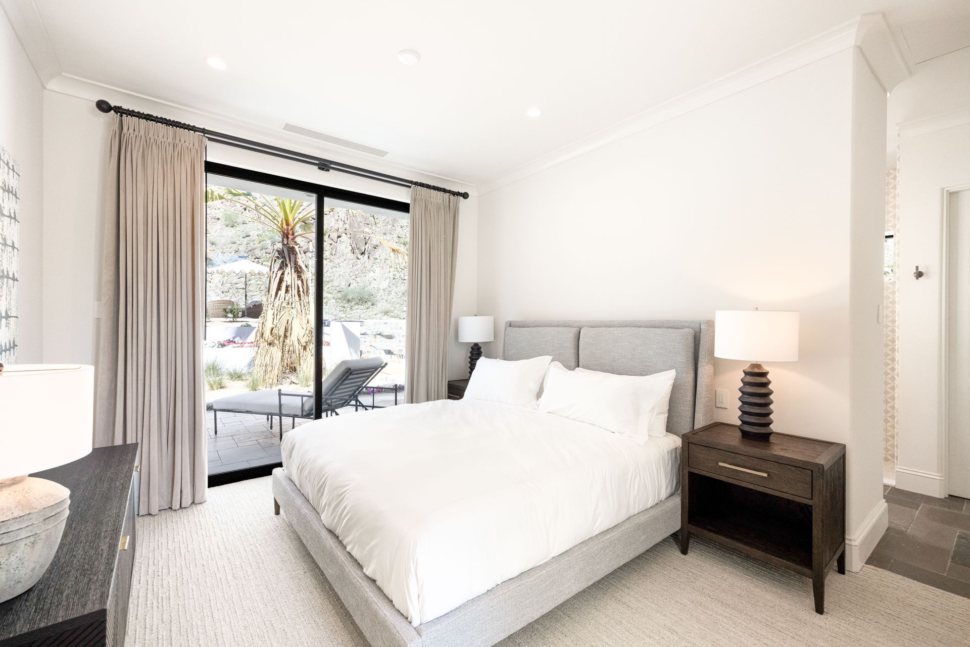 A bedroom with a large bed and a sliding glass door.