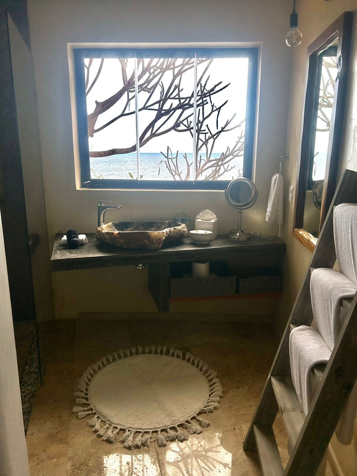 a bathroom with a sink, mirror, and ladder