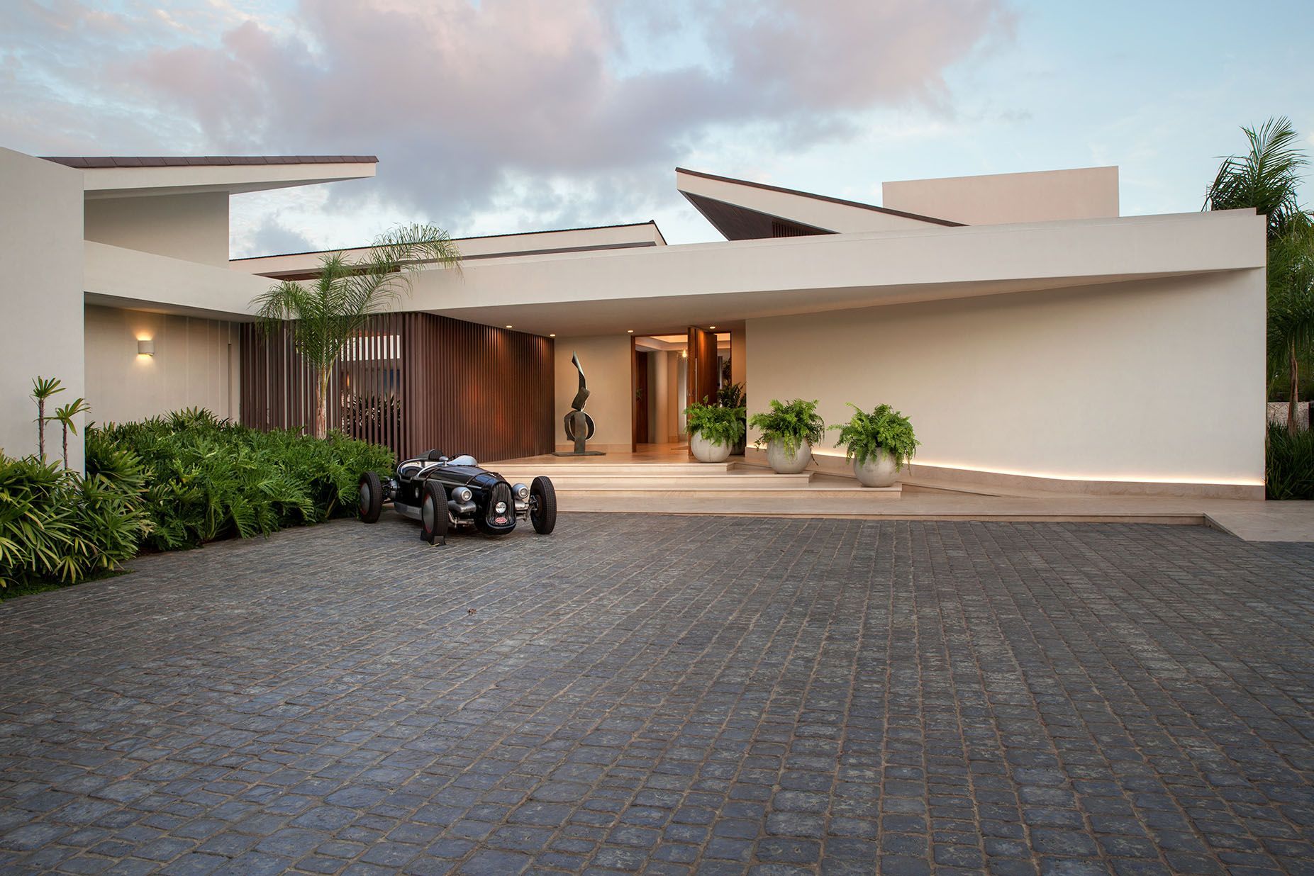 a large white house with a lot of windows is sitting on top of a lush green field