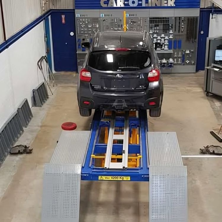 Gray SUV on a blue car lift in an auto repair shop, viewed from the rear.