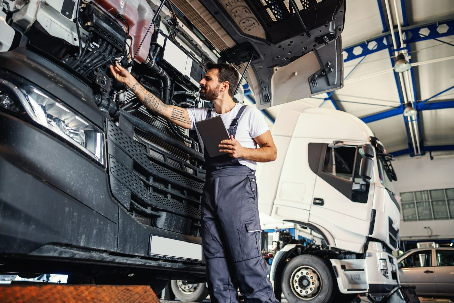 A man is working on a truck in a garage.