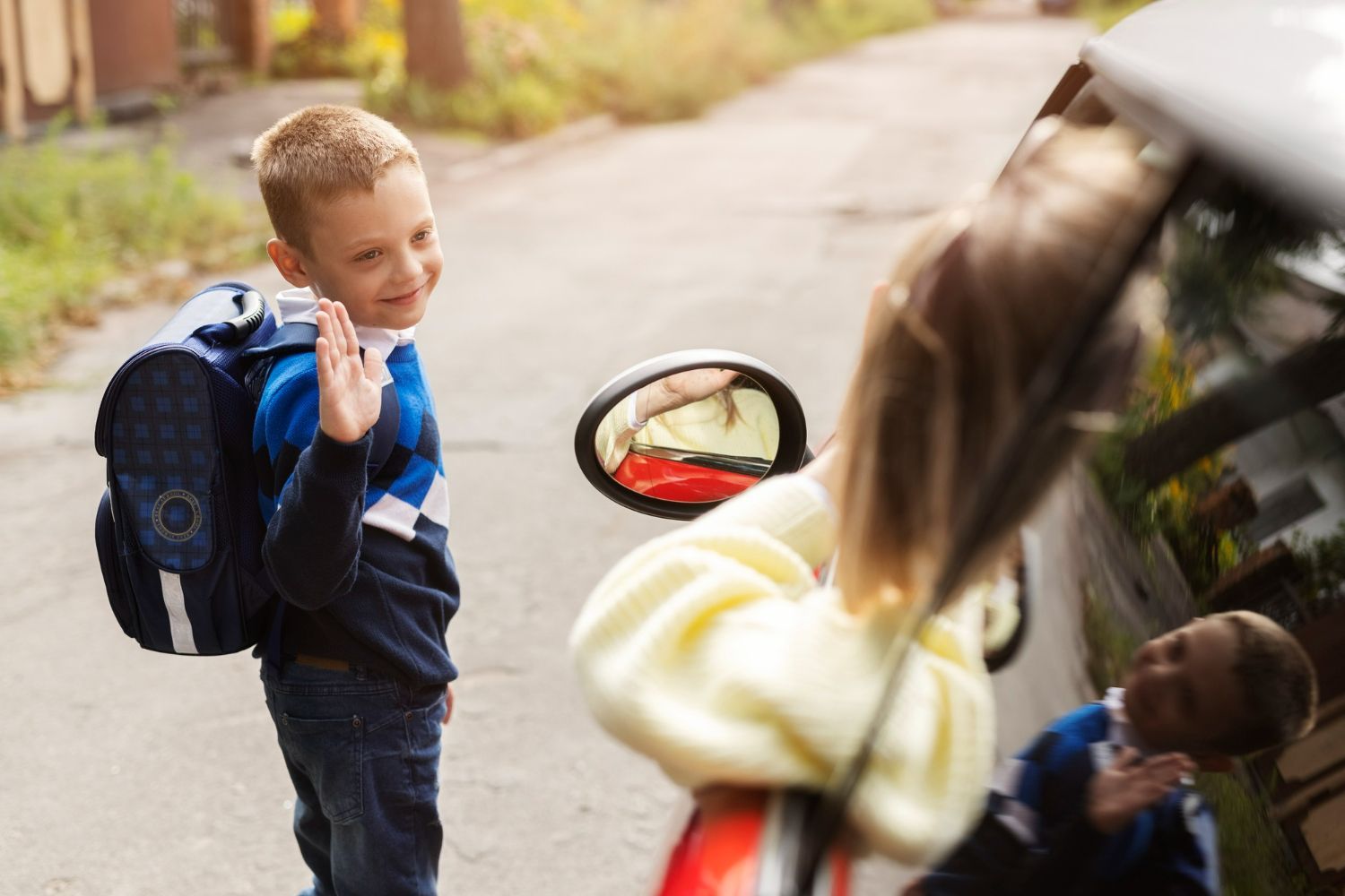 A boy and a girl are standing next to a car.