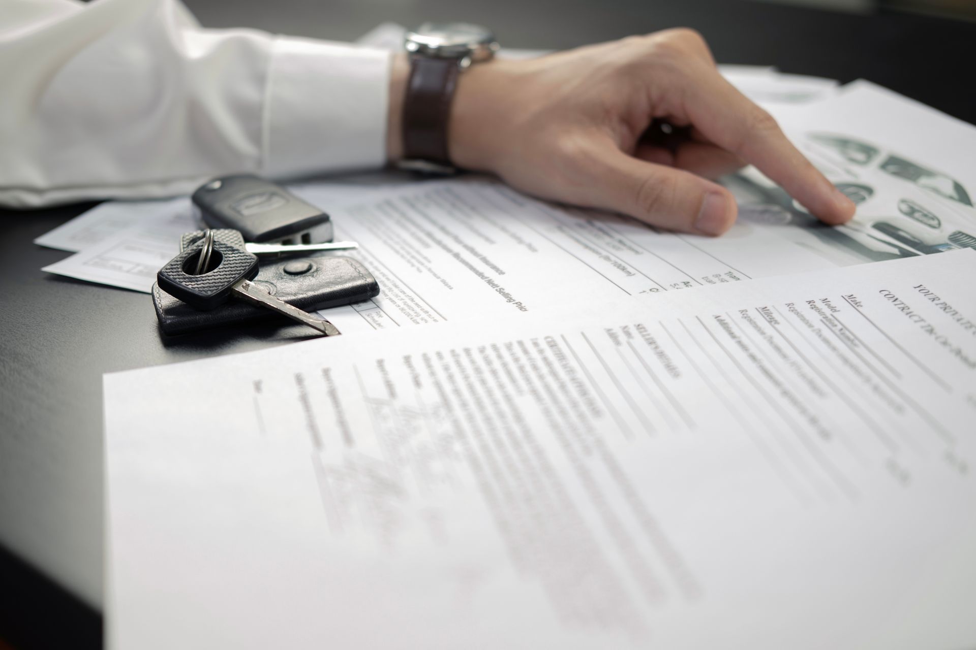 A person is pointing at a piece of paper on a table.