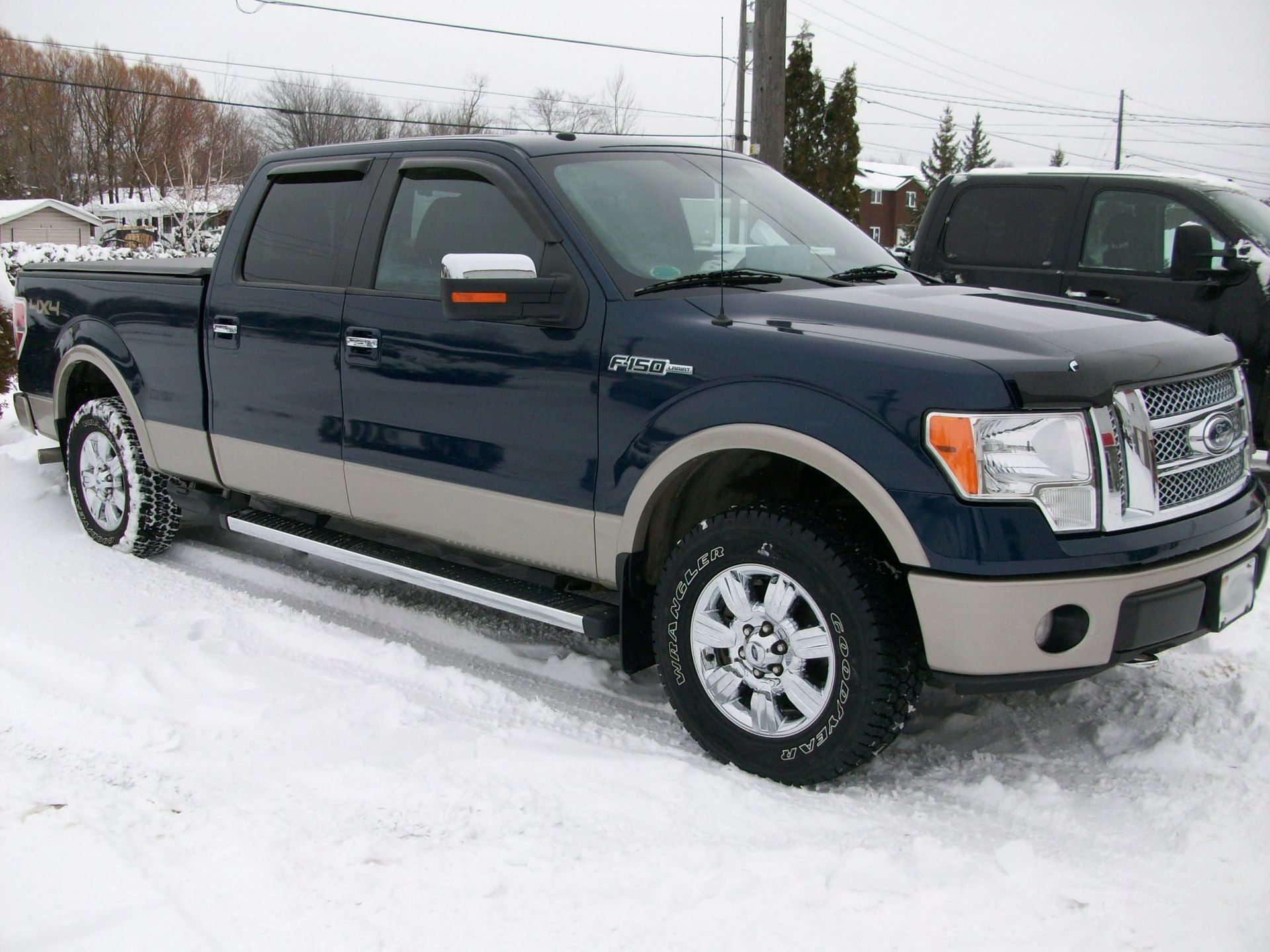 A blue ford truck is parked in the snow
