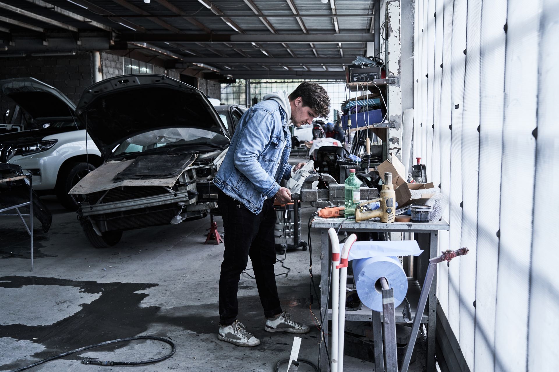 A man is working on a car in a garage.