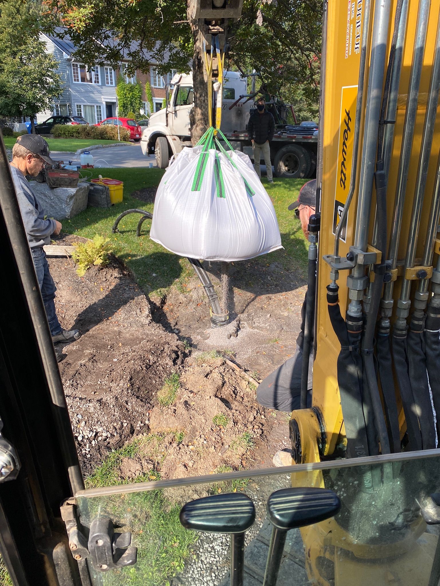 Un sac de terre est soulevé par une grue.