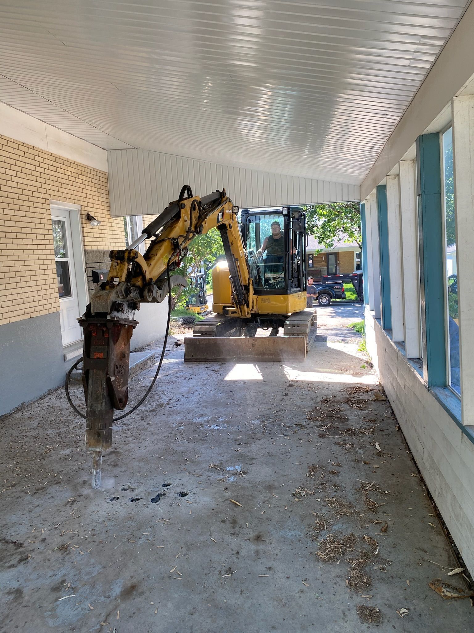 Une excavatrice jaune est utilisée pour démolir un bâtiment.