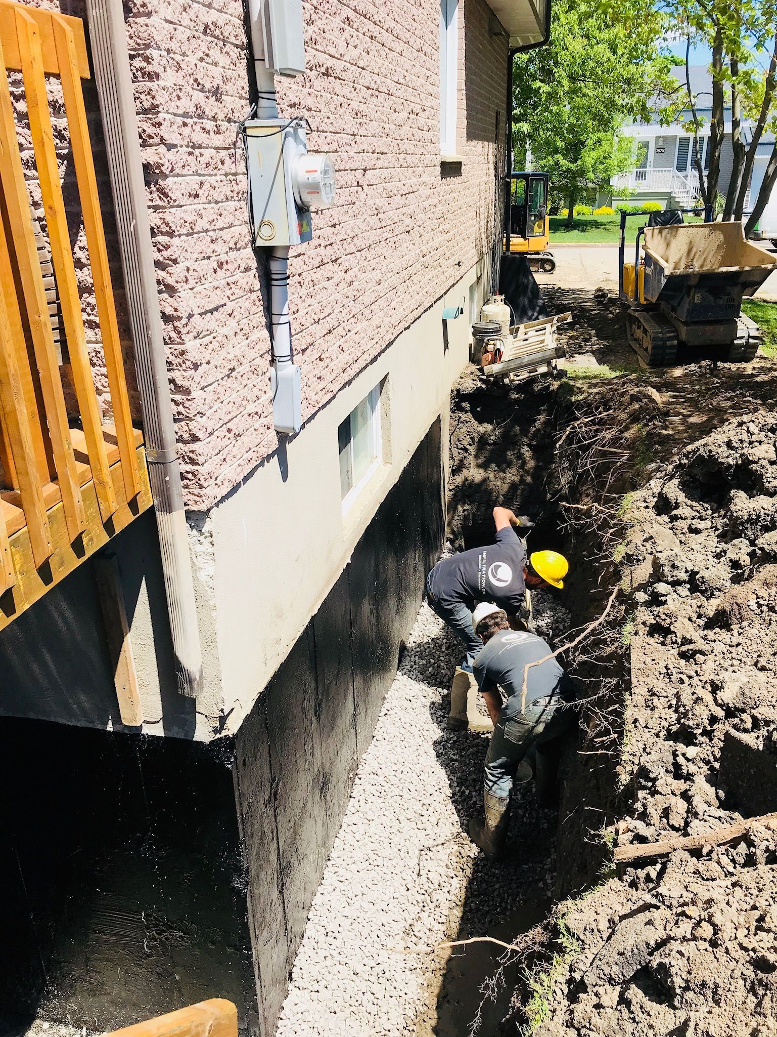 Un groupe d'hommes creuse un trou devant une maison.