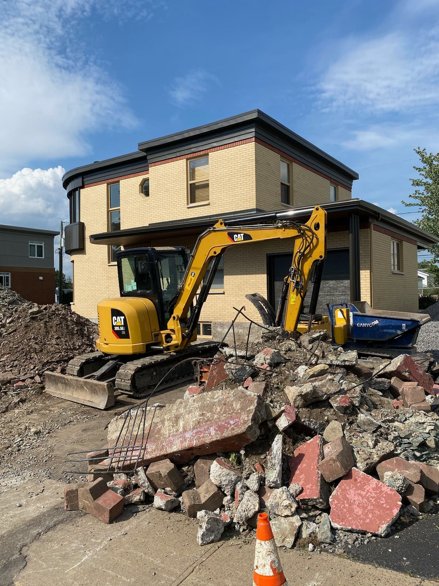 Une excavatrice jaune démolit une maison.