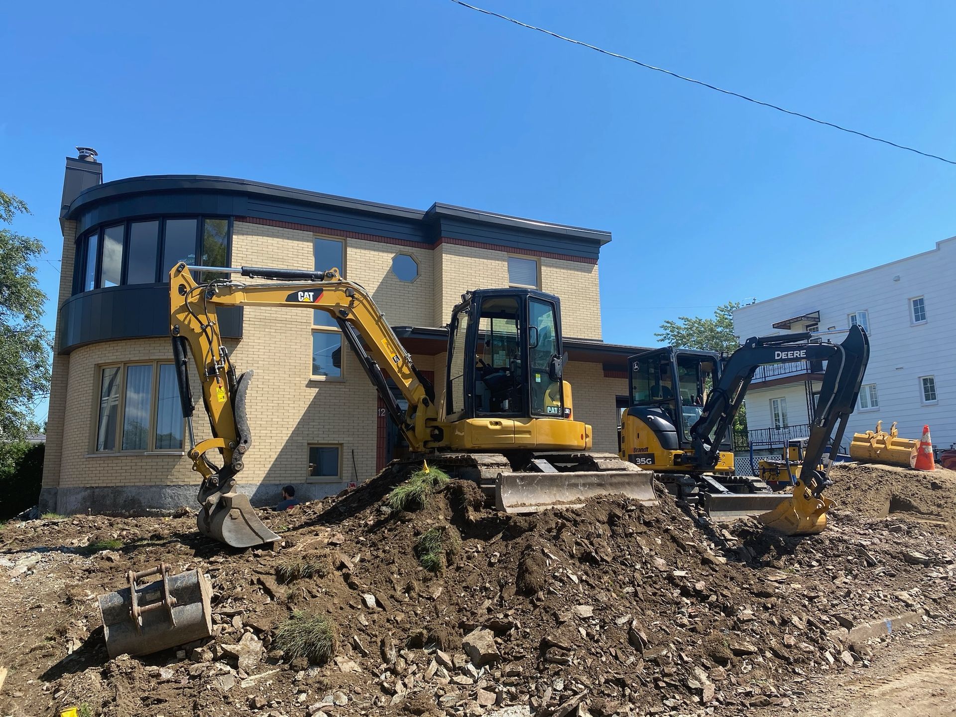 Une maison est en train d'être démolie avec un bulldozer devant elle.