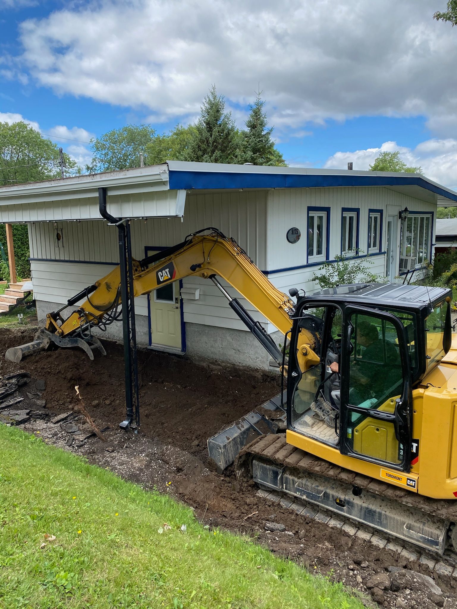 Une excavatrice jaune est utilisée pour démolir une maison.