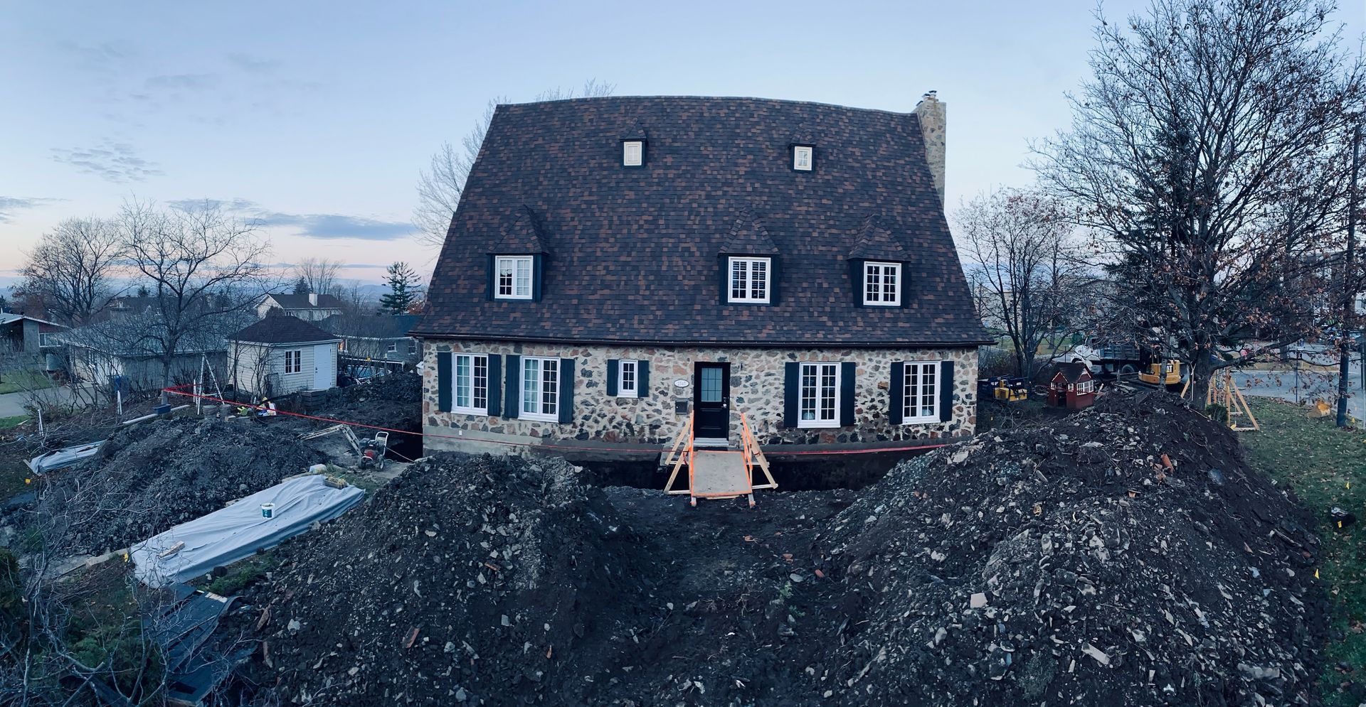 Une grande maison est assise sur un tas de terre.