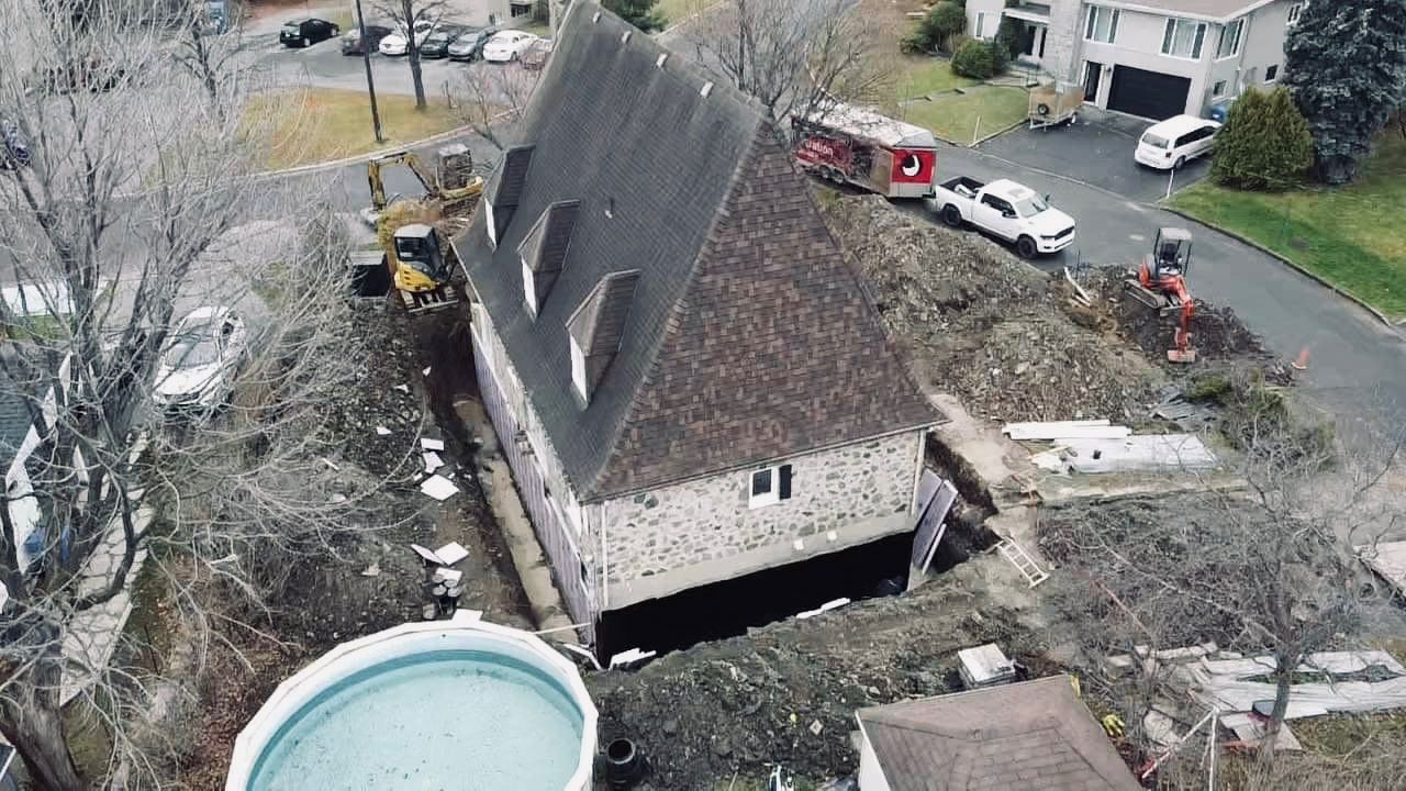 Une vue aérienne d'une maison tombée dans un trou dans le sol.
