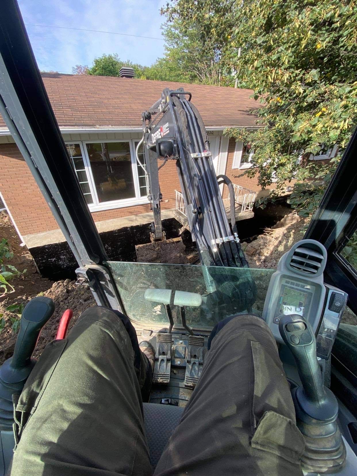 Une personne est assise sur le siège conducteur d'une excavatrice.