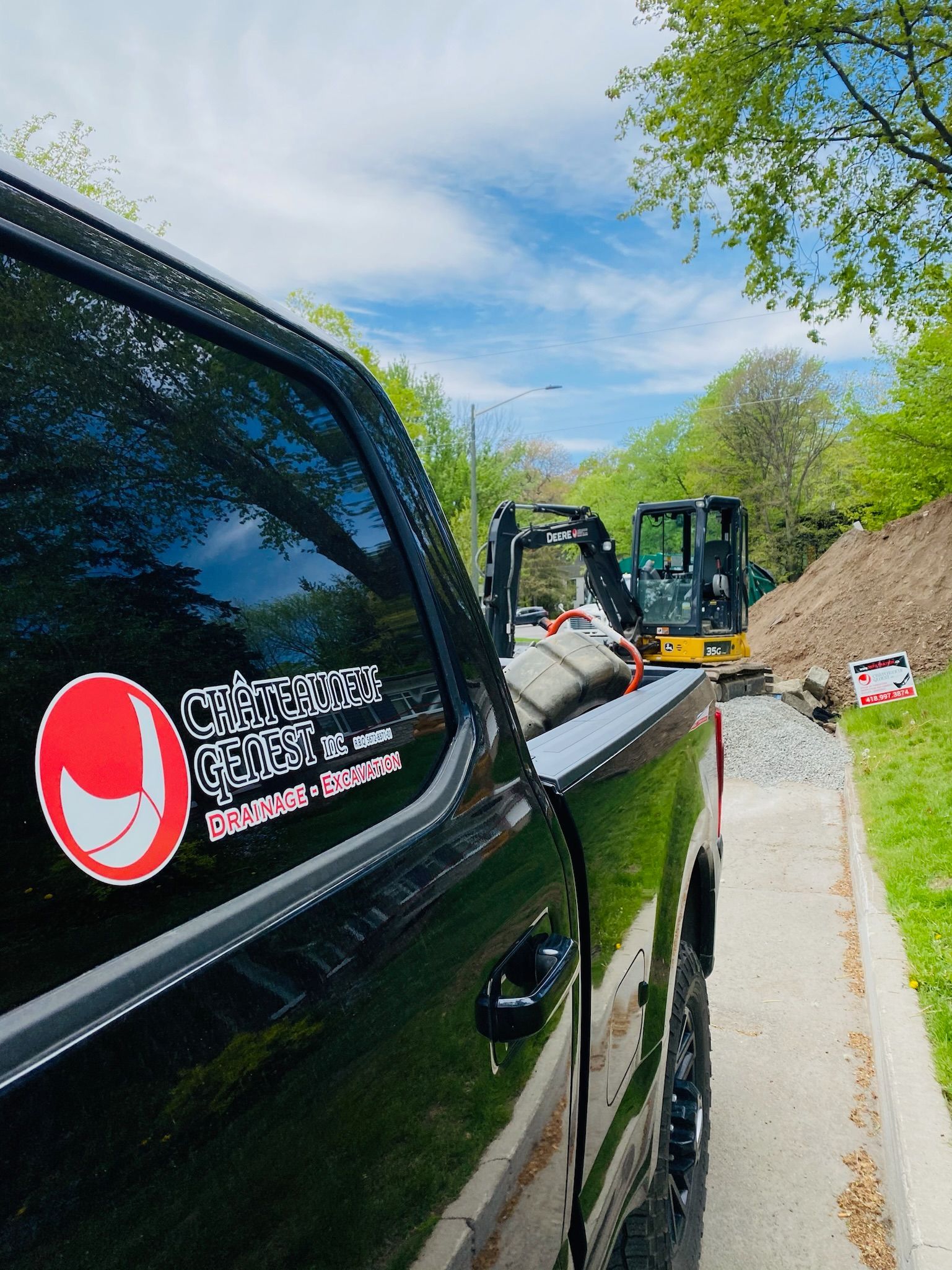 Un camion noir est garé sur le bord d'une route.
